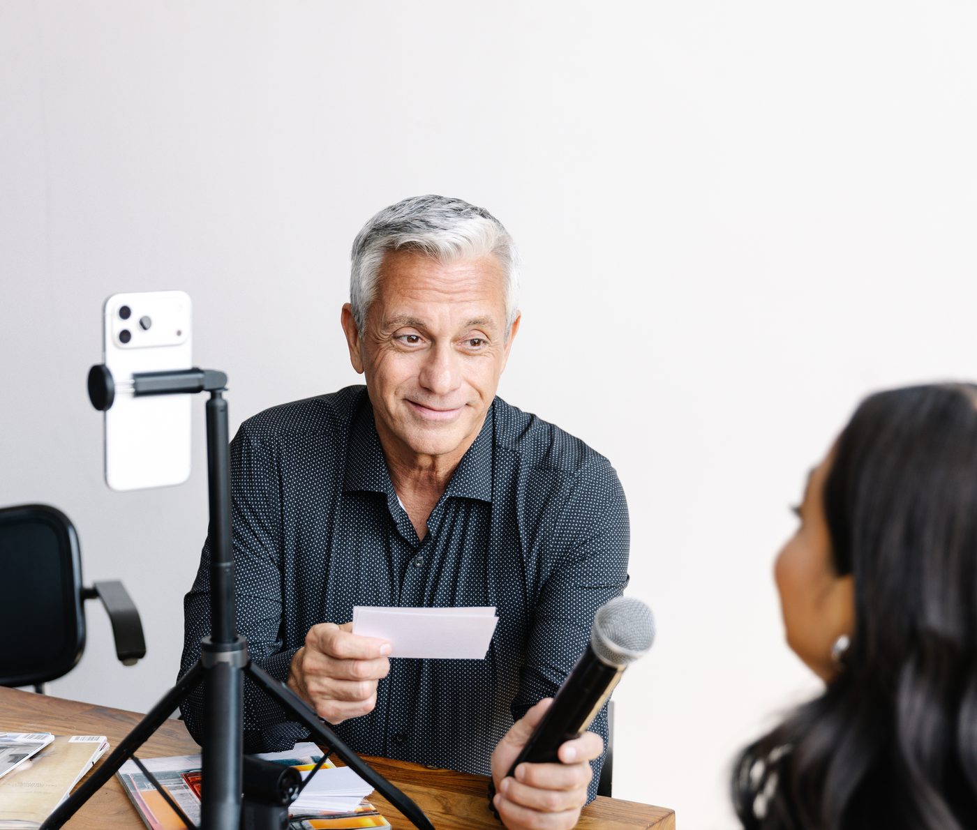 David Viggiano running a mock media interview with a client, using a microphone and a phone camera
