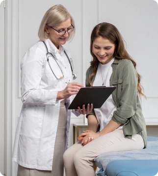 Doctor reviewing a chart with a patient in an exam room